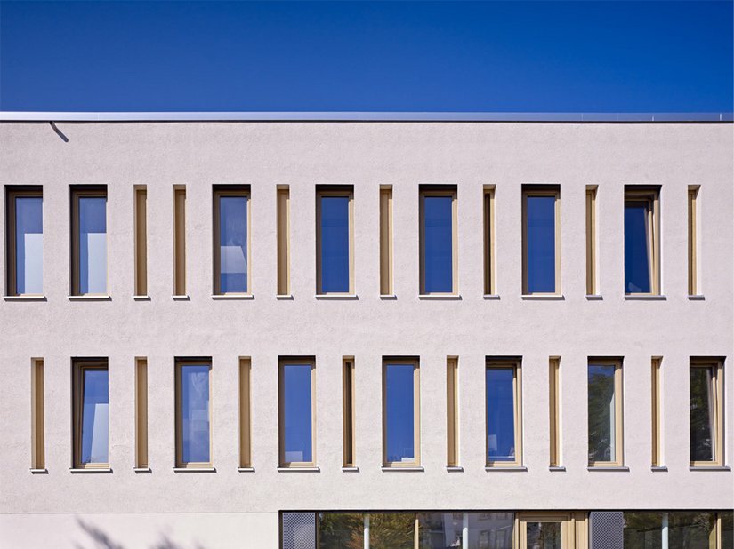 Der rückwärtige Baukörper verbindet die beiden Gebäude über die Fassadenoberflächen zu einem farblich harmonischen Ensemble.