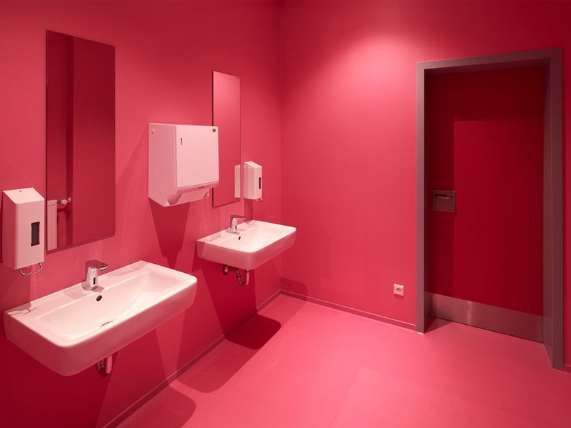 Die Wände und Decken in den WC-Bereichen sind mit kräftigen Farbtönen gestaltet.
