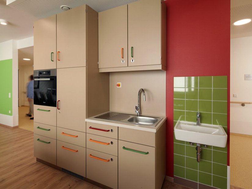 Grün und Rot geben im Innenbereich den Ton an: Grüne Farbfelder verleihen den Räumen eine beruhigende Wirkung. In Kombination mit roten Akzenten wird dem Bewohner Geborgenheit und Orientierung sowie Sicherheit gegeben.