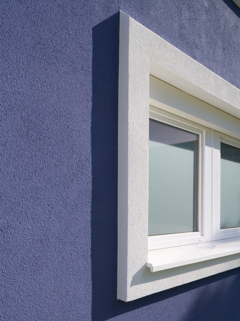 EPS-Formteile als Sonderanfertigung für Fensterstürze und -laibungen sowie dickere Qju-Dämmplattenstreifen für die untere Linie rahmen die Fensterbänder formschön ein.