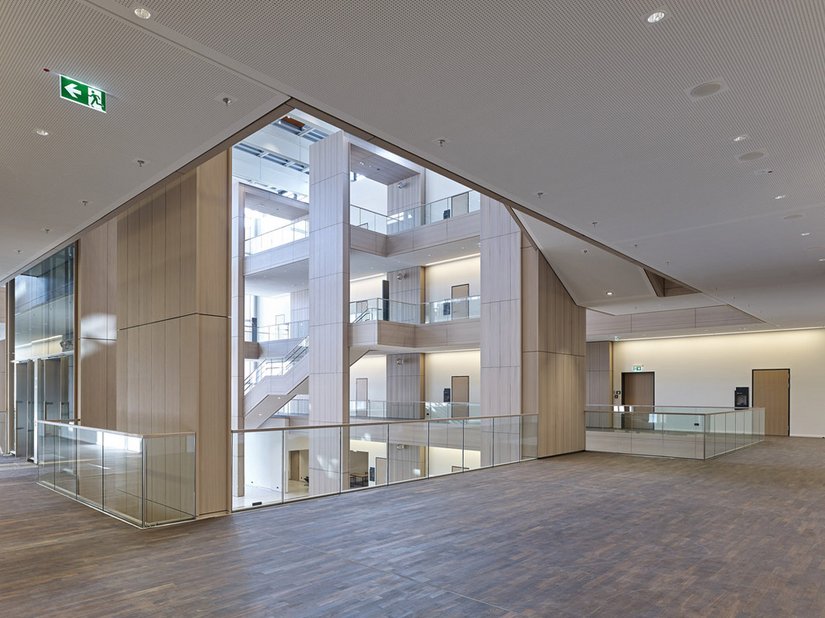 Durch die weiß gewachste Eiche wirkt das Atrium auf eine angenehm sachliche Weise skulptural und kaum wie ein öffentlicher Verwaltungsbau.