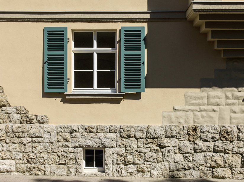 Die grünen Fensterläden, die die Gliederung unterstreichen und betonen, setzen einen kühlen, farbigen Akzent.