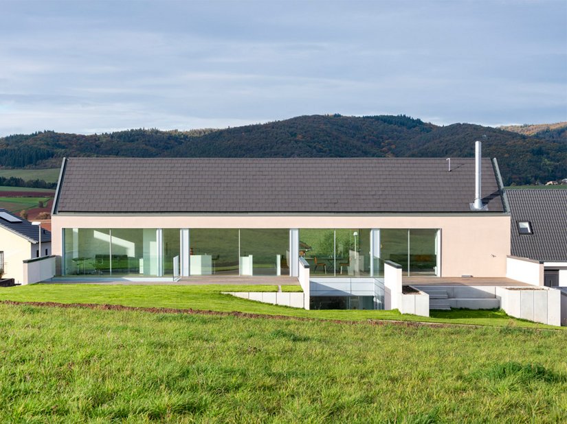 Das 2019 fertiggestellte Wohnhaus überrasch mit einer elegant-schlichten Kubatur, die zudem den natürlichen Geländeverlauf zu nutzen weiß.
Foto: ©Johannes Marburg, Genf