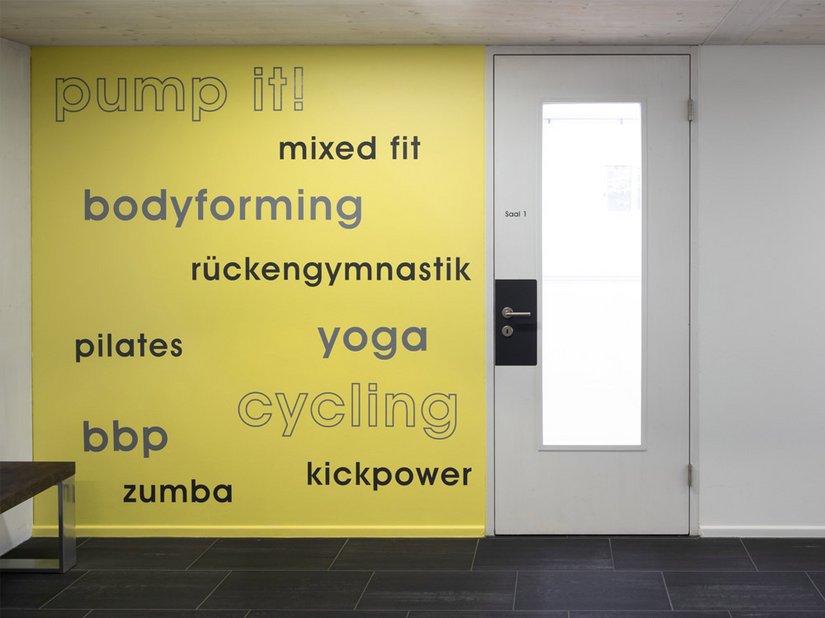 Die mit 2K-Aqua Seidenmattlack 2388 lackierte Wandfläche gibt eine Übersicht über das vielfältige Angebot des Fitnesscenters.