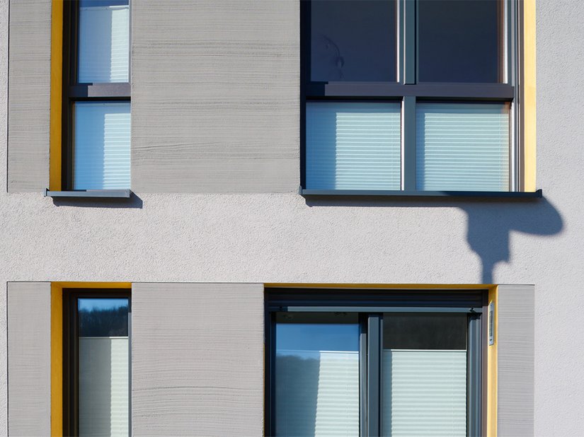 Besenstrichoptik trifft auf Kratzputz trifft in den Fensterlaibungen auf Glattputz in Sonnengelb: Verschiedene Brillux Produkte erzeugen die hohe Qualität der Fassadengestaltung.