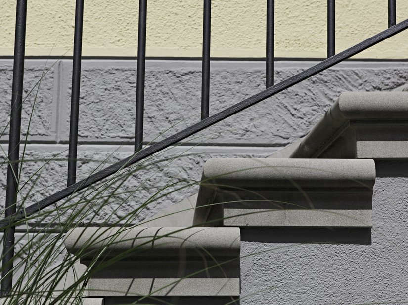 <p>Detailaufnahme von einer Treppe und dem farblichen Übergang zwischen Sockel und Fassadenfläche.</p>