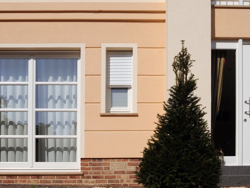 Die Fensterbank aus Sandstein nimmt den Farbton des Klinkersockels auf und ordnet sich der Gesamtgestaltung des Hauses in angenehmer Art unter. Der Farbton des Obergeschosses wiederholt sich an den deutlich wahrnehmbaren Faschen und Leibungen im Erdgeschoss.