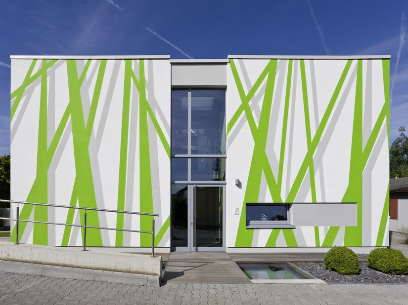 <p>Der nur von wenigen Öffnungen durchbrochene, weiße Baukörper wird durch ein Fassadenlayout in Szene gesetzt, das die Corporate Identity des Unternehmens reflektieren soll.</p>