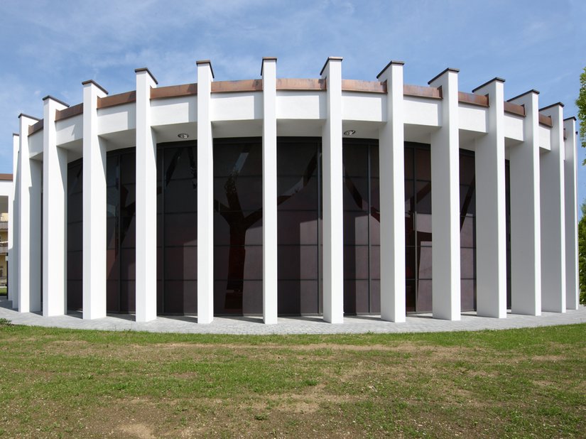 Hinter den Stützen rund um die Kapelle entdeckt man die abstrakten Bäume in der Glasfassade.