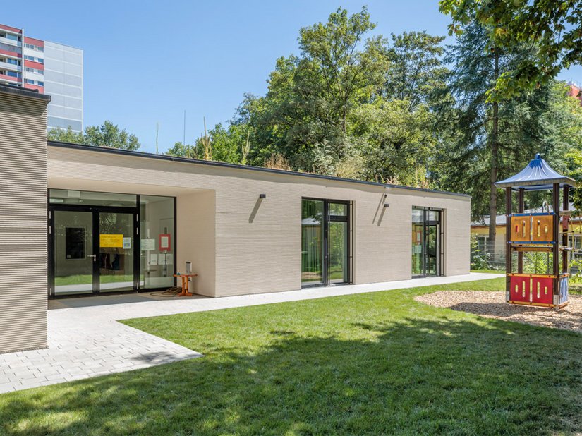 Der neue Anbau ergänzt das Ensemble aus Kirche, Pfarrhaus und bestehendem Kindergartenbau.