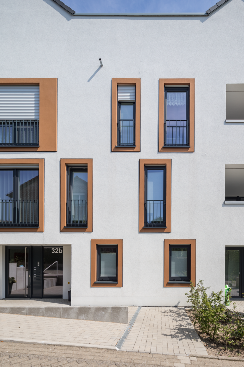 Eine inspirierende Idee zur Fassadengestaltung: Die mit Dämmmaterial ausgestalteten Fensterfaschen geben dem Gebäude-Ensemble eine spielerische Leichtigkeit.