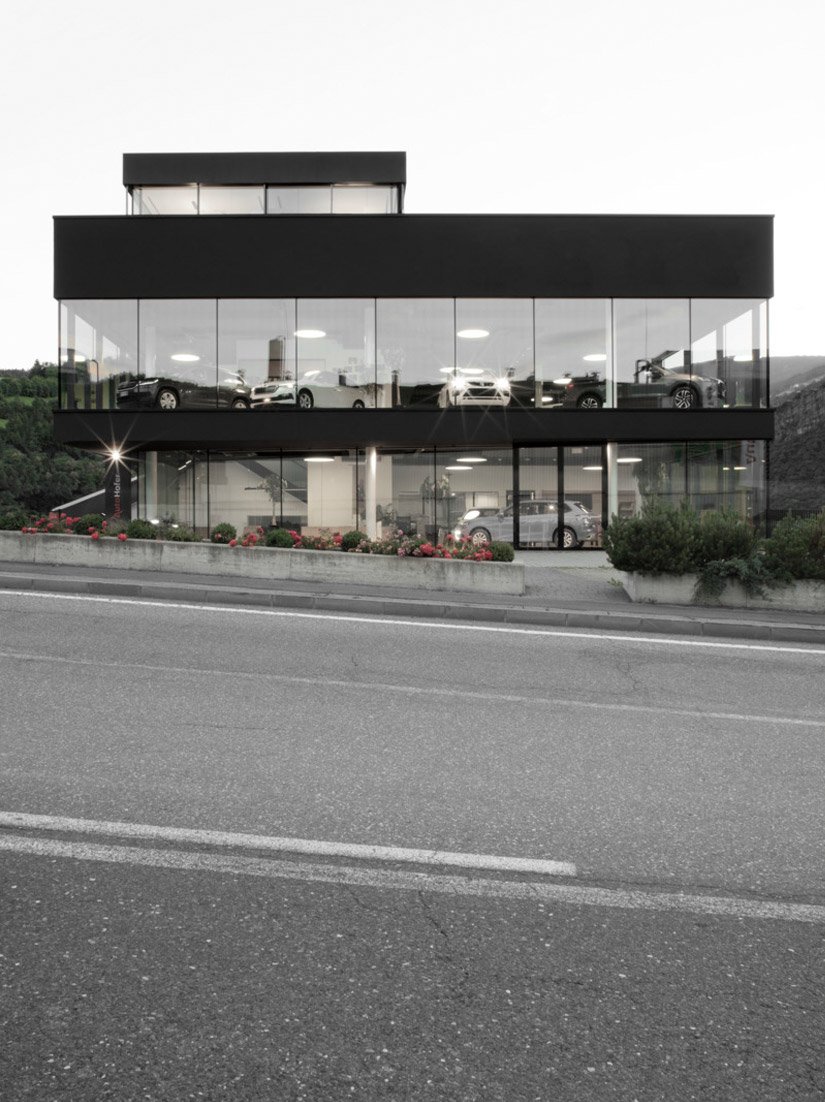 <p>Das Gebäude unterstreicht seine prägnante Erscheinung durch große Glasfronten und eine monochrome Farbgebung in dunklem Anthrazit.</p>