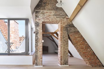 <p>Ein gemau­erter Schornstein, die Holzbalken und der Dachstuhl erinnern an die Vergangen heit. Die alten Holzfenster wurden rekon­struiert. Alle neu eingebauten Fenster, die Treppen und Balkone bestehen aus Stahl.</p>