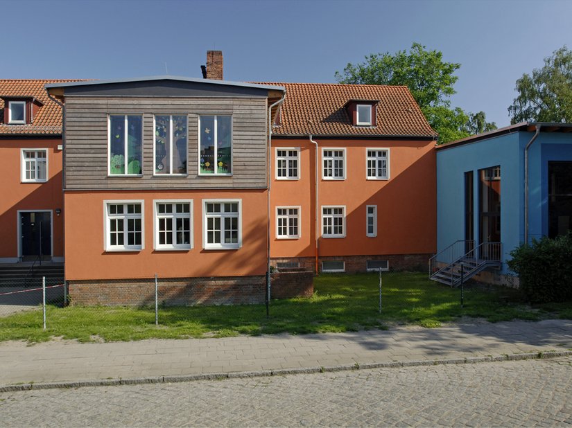 Scala Farbtöne: Fassade: 21.15.18, Fassade Anbau: 69.18.15, Sockel: 03.03.15, Faschen: 03.03.12, Anbau Absetzton: 69.15.21, Eingangstüren: 72.15.30 (RAL 5020), 72.18.24 (RAL 5021), 30.18.33 (RAL 3004), 27.21.27 (RAL 3002)