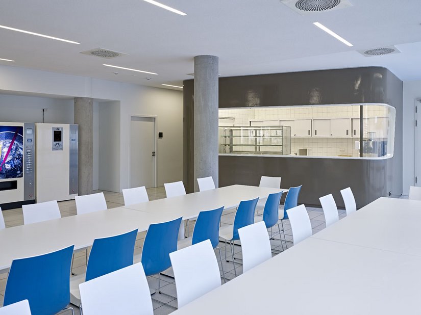 <p>Sowohl der Empfang wie auch die Theke der Cafeteria sind als "frei" geformte, gerundete Raumelemente in das weitläufige Foyer eingestellt.</p>