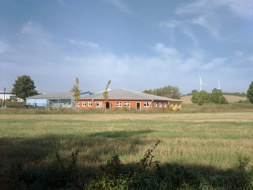 Die kunterbunte Wohneinrichtung sticht aus der ländlichen Idylle leuchtend hervor.