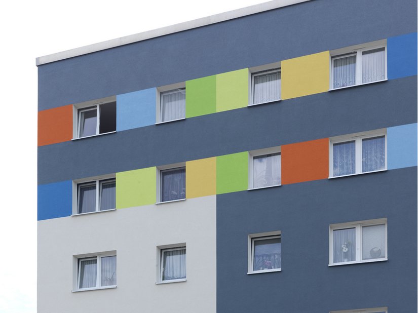 Die eingesetzten Farbtöne Blau, Rot, Grün und Orange verleihen dem Plattenbau eine erkennbare Fröhlichkeit.