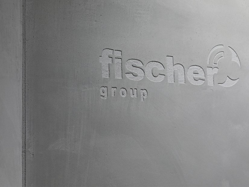 Wie ein Siegel: Das Logo der fischer group hielt als Schabloniertechnik Einzug in die Schalbetonoptik-Fläche.