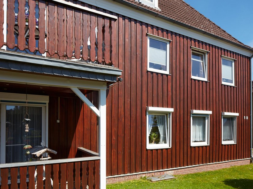 Nicht nur die Holzfassade, sondern auch die Balkonumgrenzungen wurden in einem hellen Mahagoni-Farbton gestrichen.