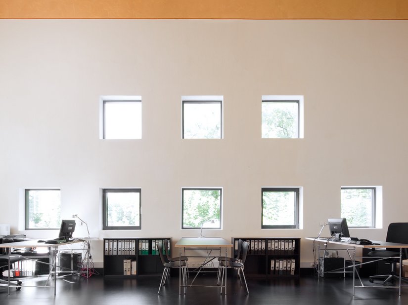 <p>Die Nordgiebelseite von innen: Die acht quadratischen, geometrisch angeordneten neuen Fenster belichten den Büroraum.</p>