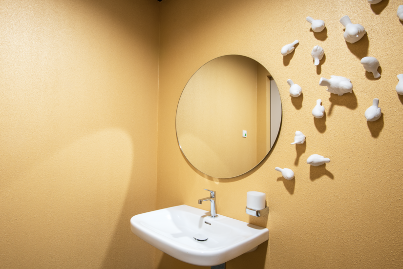 Ästhetisch und gleichzeitig widerstandsfähig gestaltete das Malerteam die Waschräume. Mit Creativ Lucento und 2K-Aqua Seidenmattlack schufen sie goldene Oberflächen, die gegen Spritzwasser geschützt sind.