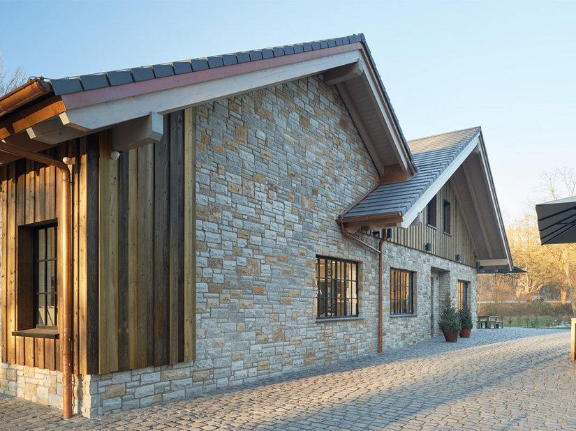 Die Fassade ist mit Bruchsteinen verkleidet, die dem Restaurant im Zusammenspiel mit den speziell angefertigten gusseisernen Sprossenfenstern einen rustikal-modernen Look geben.