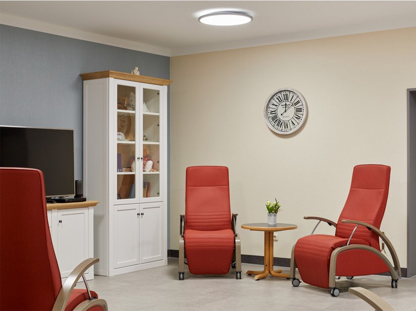 Sienafarbene Sessel sorgen in dem ansonsten farblich zurückhaltend gestalteten Wohnbereich für warme Akzente.