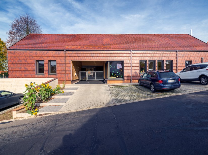 Ziegel auf der Außenfassade sowie Holzverkleidungen und versiegelter Sichtbeton im Inneren: Nachhaltig gestaltet sollte der Neubau des Kindergartens in Motten sein. Mit Lignodur Grenodecor erstellten die Maler/-innen einen robusten Holzschutz, der die Ästhetik der Bauteile betont.