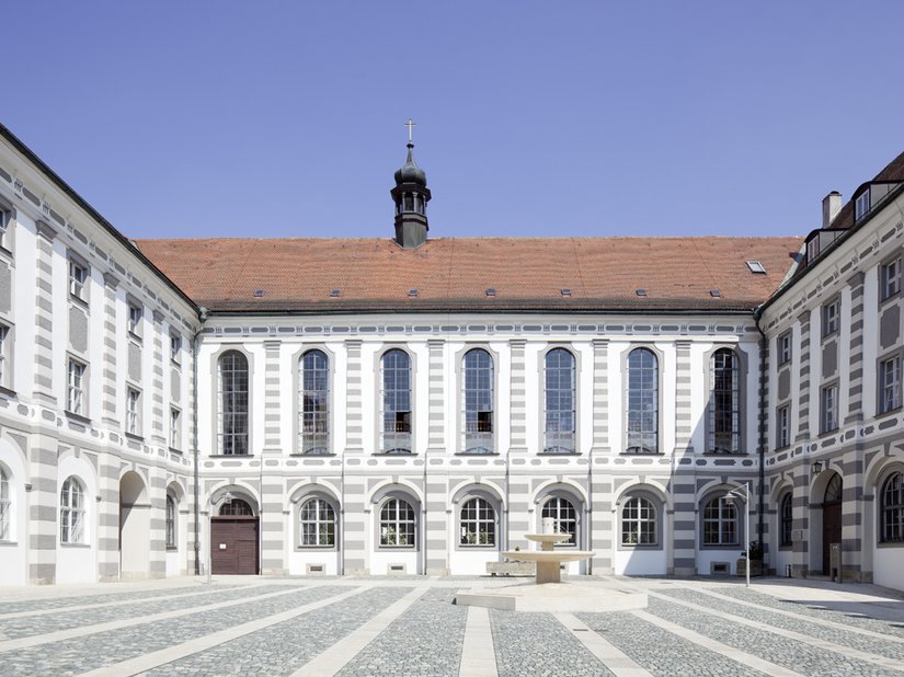 Ein lang gestreckter Seitenflügel, die Stiftsbasilika und zwei weitere jeweils um zwei Innenhöfe gruppierte Gebäudekomplexe: Das beeindruckende Volumen der Klosteranlage mit seinen 9.000 Quadratmetern Fassadenfläche erschließt sich dem Besucher erst nach und nach.