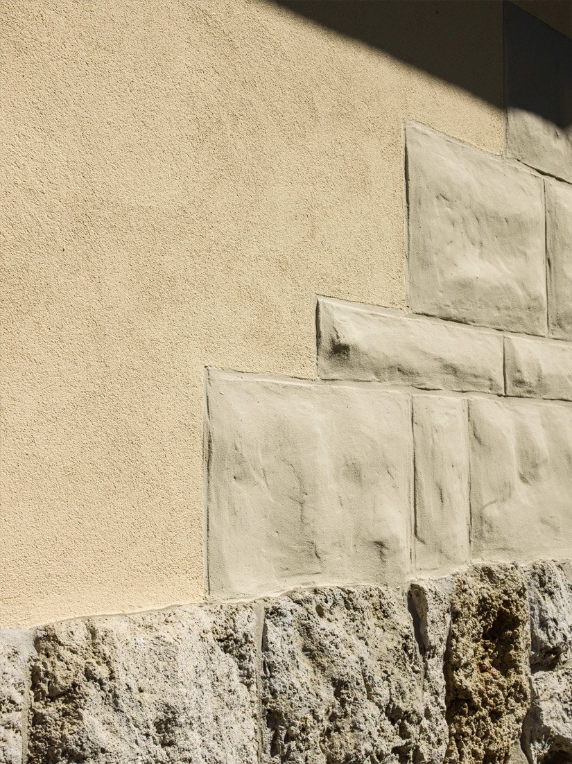 <p>Die in die Putzflächen kragenden Rustiken über dem Natursteinsockel integrieren sich sensibel in die Fassade.</p>