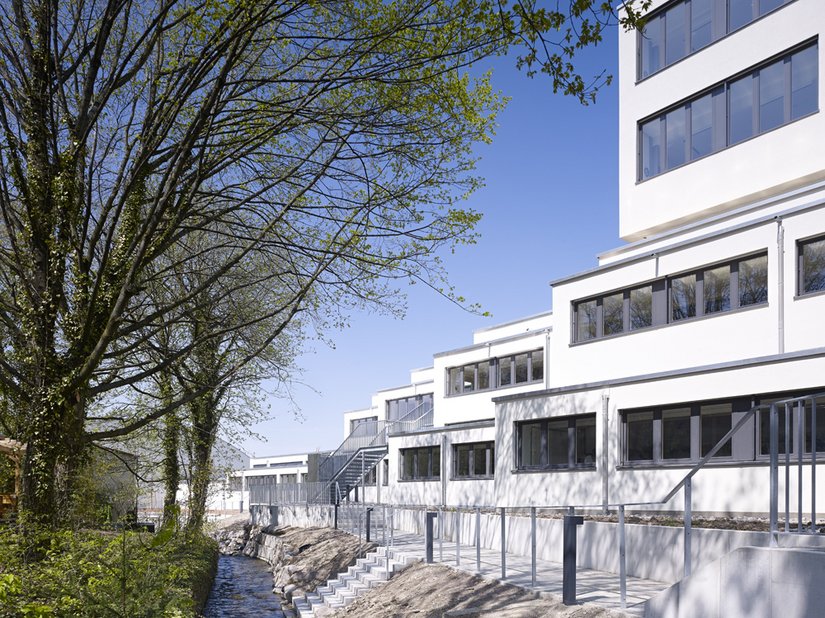 Kontraste setzen dunkle Holz-Aluminium-Fenster, die für die Fensterbänder verwendet wurden.