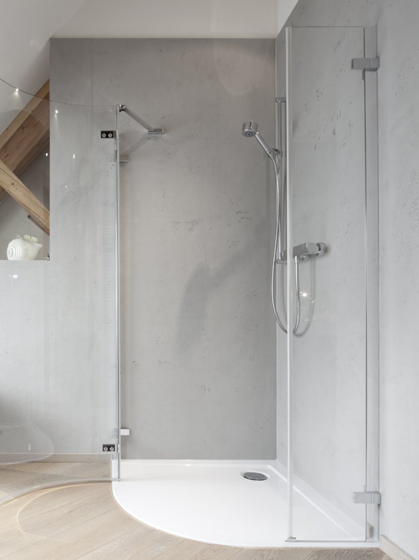 <p>Die Dusche mit Glaswänden passt sich dem modernen Stil der Wohnung an.</p>