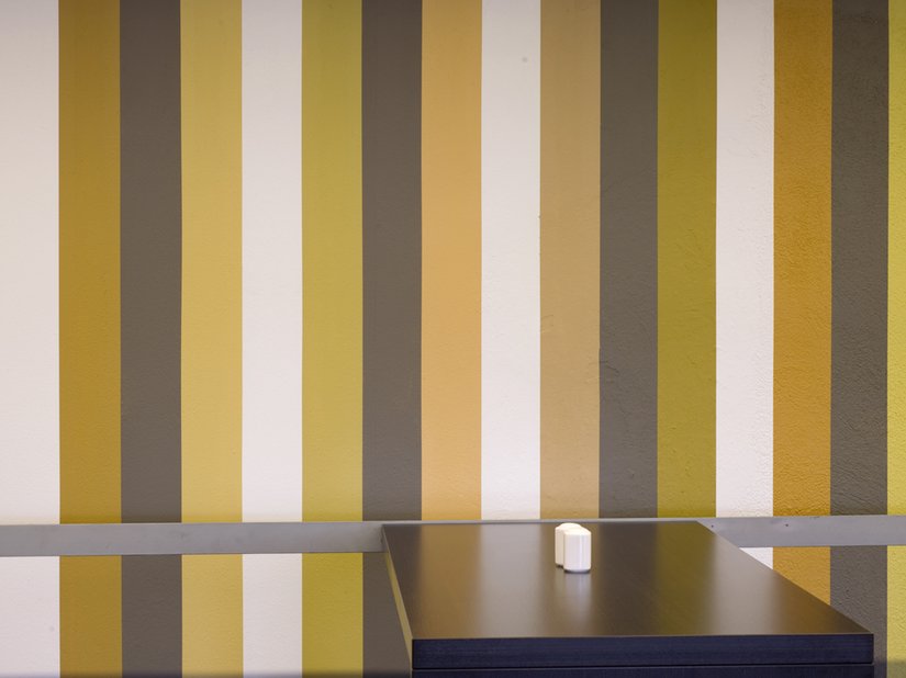<p>Farbige Streifen-Kompositionen, hinter denen ein feinsinniges Konzept steckt, verlaufen durch die Räume und Flure.</p>