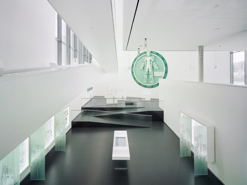 <p>Eine menschliche Gestalt in der Firmenfarbe des B. Braun Konzerns ziert die über 14 m hohe Ausstellungshalle der Aesculap Akademie.</p>