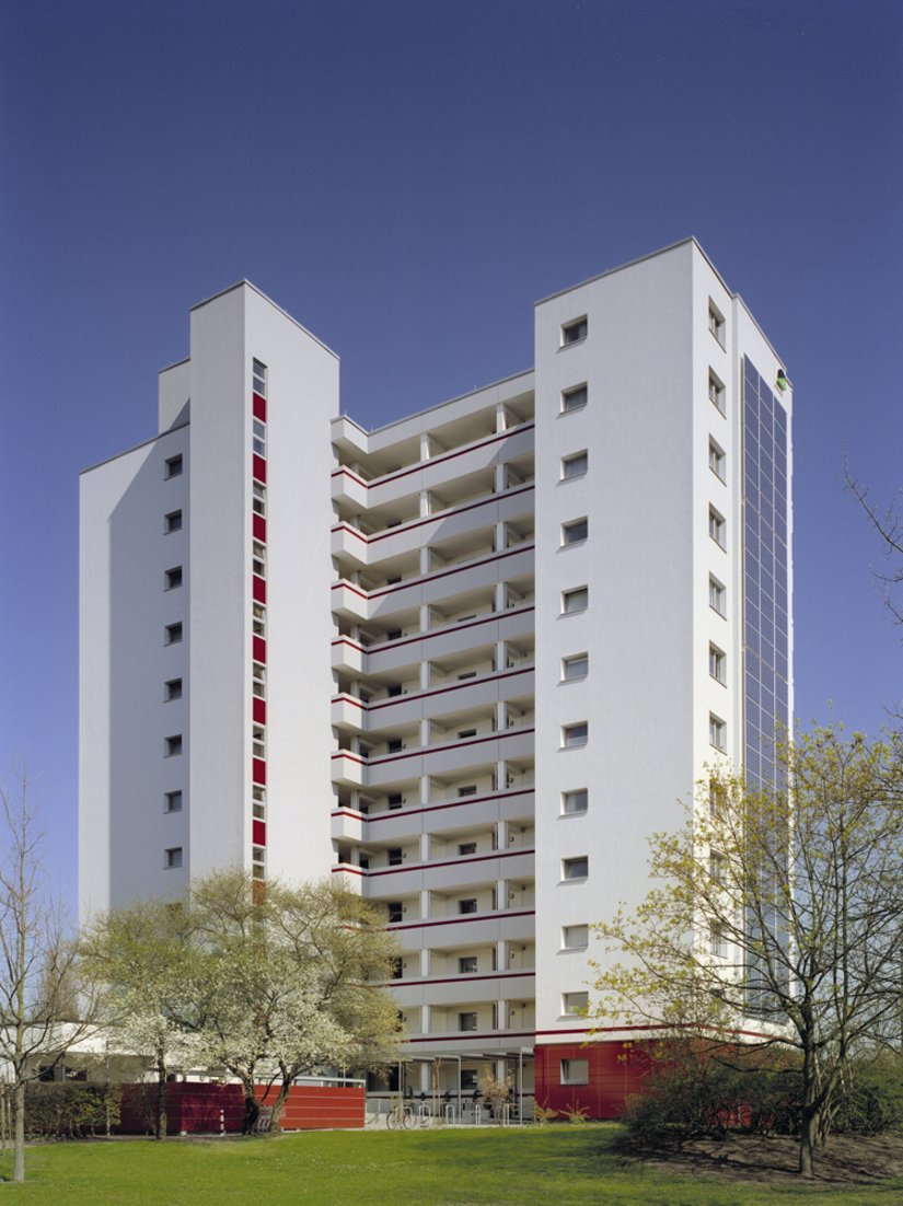 Der Rotfarbton der keramischen Beläge findet sich als horizontale Gliederung in den Loggiengängen und als vertikales Fensterband wieder.