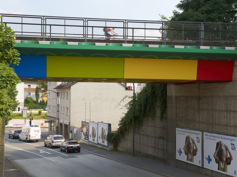 Die in Volltönen geplante Malerei unterstreicht die vorgegebene Konstruktion der Brücke.